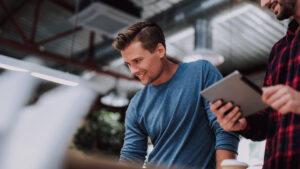 Zwei Männer die in einem Industriebetrieb an Tablets arbeiten als Sinnbild für Digitalisierung.